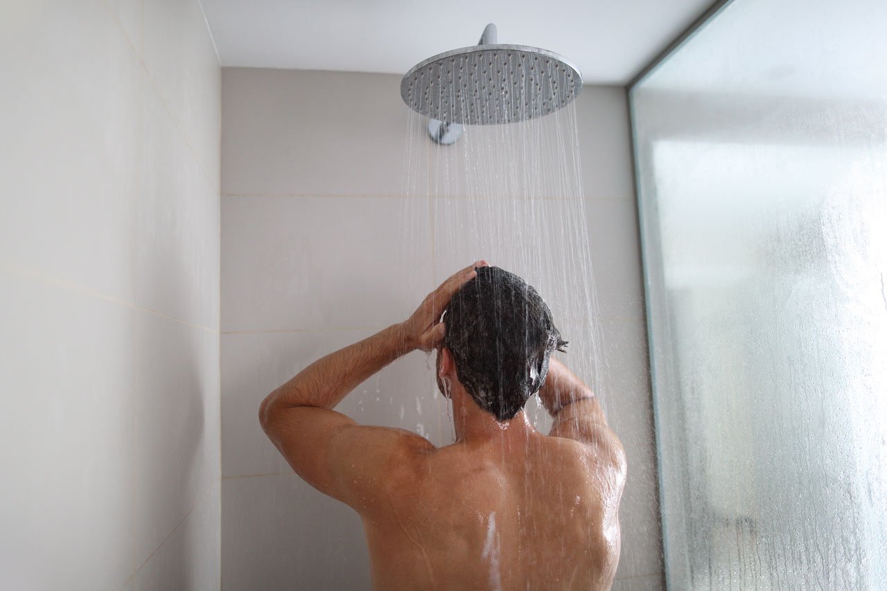 Mann beim Kreislauf in Schwung bringen durch kaltes Duschen