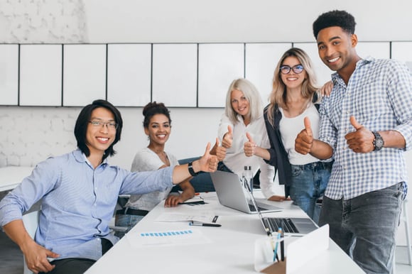blonde-secretary-sitting-table-while-office-workers-posing-with-thumbs-up-indoor-portrait-happy-asian-manager-trendy-shirt-smiling-conference-hall-with-foreign-partners (1)
