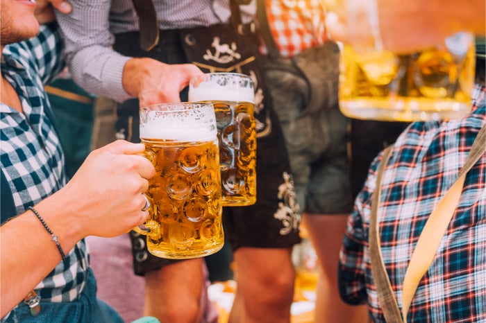 Männer trinken auf einem Oktoberfest Bier und vergessen komplett das Alkohol und Abnehmen nicht zusammen passen.