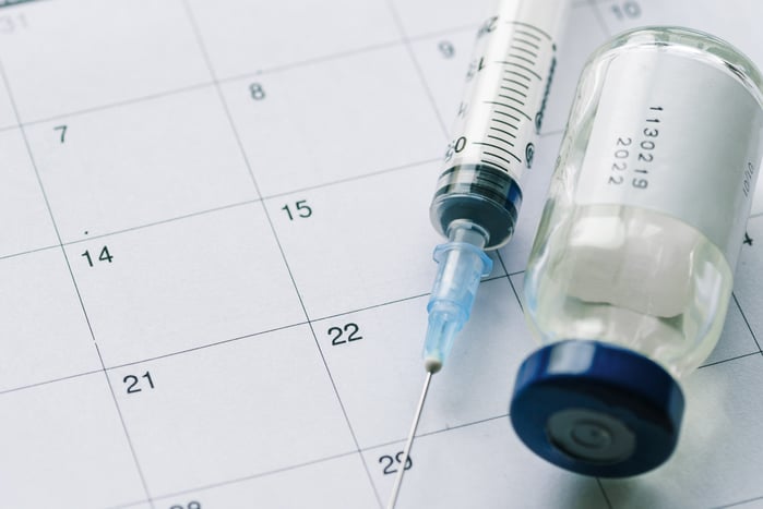 the-vial-with-vaccine-and-syringe-on-calendar-3A5Q7KS-min