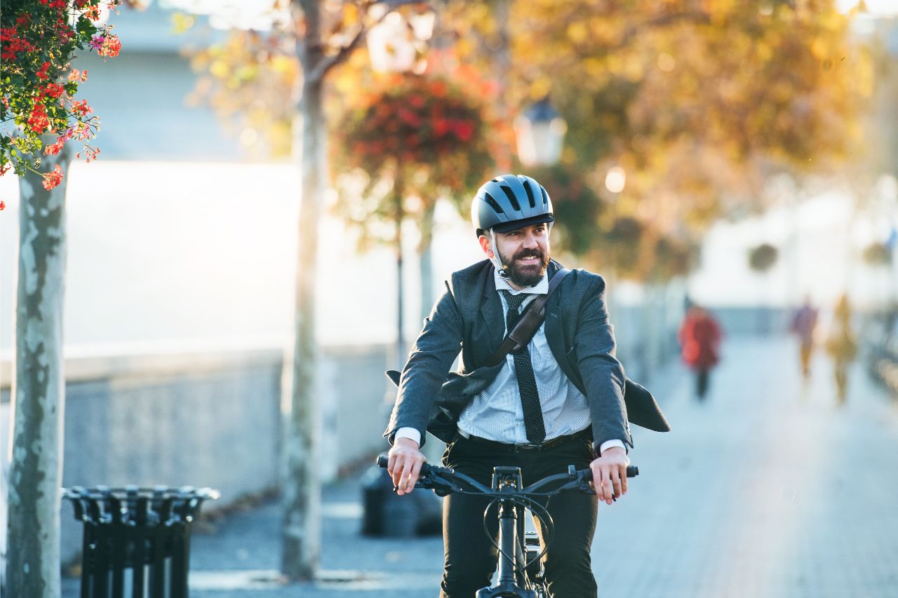Mann fährt auf einem Fußweg mit dem Fahrrad zur Arbeit